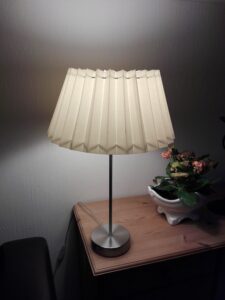 Sød og hyggelig lille lampe fra Dana Light. Lampen er med hvid plissé skærm og er 52 cm høj. Der er en lille skade under lampens fod - se billede. Pære medfølger! Pris 225,- Ved fragt +100,-